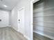 Hallway with wood-style flooring, pantry with wire shelves, and entry door at 12524 Garrett Pl, Grand Island, FL 32735