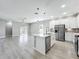 Bright, open-concept kitchen features stainless appliances, modern cabinetry, and a large island with pendant lighting at 12524 Garrett Pl, Grand Island, FL 32735