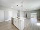 Modern kitchen boasts an island with sink, stylish pendant lights, and open floor plan, creating a seamless living space at 12524 Garrett Pl, Grand Island, FL 32735