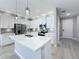 Modern kitchen featuring white cabinets, stainless steel appliances, an island with a sink, and pendant lighting at 12524 Garrett Pl, Grand Island, FL 32735