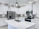 Bright kitchen with white cabinets, stainless steel appliances, center island, and modern pendant lighting at 12524 Garrett Pl, Grand Island, FL 32735