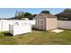 Backyard shed provides extra storage; white fence ensures privacy for outdoor activities at 12524 Garrett Pl, Grand Island, FL 32735