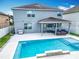 A stunning backyard featuring a sparkling pool, covered patio, and outdoor kitchen area at 12627 Boggy Pointe Dr, Orlando, FL 32824