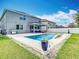 Expansive backyard featuring a sparkling pool, covered patio, and meticulous landscaping at 12627 Boggy Pointe Dr, Orlando, FL 32824