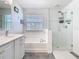 Bright bathroom features a soaking tub, glass shower, and updated vanity at 12627 Boggy Pointe Dr, Orlando, FL 32824