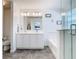Well-lit bathroom with a double vanity, framed mirror, and a glass-enclosed shower and tub at 12627 Boggy Pointe Dr, Orlando, FL 32824