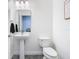 Bathroom featuring white fixtures including the toilet and pedestal sink at 12627 Boggy Pointe Dr, Orlando, FL 32824