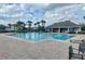 Community pool featuring lounge chairs and palm trees at 12627 Boggy Pointe Dr, Orlando, FL 32824