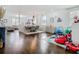 Open concept dining area with contemporary lighting, hardwood floors, and a view into the living room and play area at 12627 Boggy Pointe Dr, Orlando, FL 32824