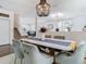 Elegant dining room featuring a modern light fixture, with seating for six and views of the staircase and living spaces at 12627 Boggy Pointe Dr, Orlando, FL 32824