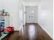 Bright hallway featuring sleek hardwood floors, leading to a front door with decorative glass insert at 12627 Boggy Pointe Dr, Orlando, FL 32824