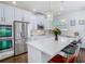Bright kitchen featuring white cabinetry, stainless steel appliances and an island bar at 12627 Boggy Pointe Dr, Orlando, FL 32824