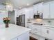 Kitchen featuring white cabinetry, stainless steel appliances and pendant lighting at 12627 Boggy Pointe Dr, Orlando, FL 32824