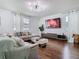 Spacious living room featuring hardwood floors, a large sectional sofa, and modern lighting at 12627 Boggy Pointe Dr, Orlando, FL 32824