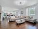 Bright living room with hardwood floors, large sofa, and open access to the dining area and kitchen at 12627 Boggy Pointe Dr, Orlando, FL 32824