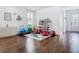 Inviting living room with hardwood flooring that transitions to a playroom filled with toys and ample natural light at 12627 Boggy Pointe Dr, Orlando, FL 32824