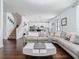 Bright living room with hardwood floors, staircase, and large sofa perfect for entertaining guests at 12627 Boggy Pointe Dr, Orlando, FL 32824