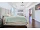 Bright main bedroom featuring hardwood floors, a tray ceiling and doorway to a playroom at 12627 Boggy Pointe Dr, Orlando, FL 32824