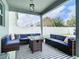 Relaxing covered patio area with cozy wicker seating, a modern fire pit, and stylish outdoor lighting at 12627 Boggy Pointe Dr, Orlando, FL 32824