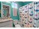 Bathroom showcasing floral shower curtain and teal painted walls at 13042 Michael Callin Aly, Orlando, FL 32828