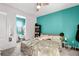 Bedroom with bright teal wall, ceiling fan and view into bathroom at 13042 Michael Callin Aly, Orlando, FL 32828