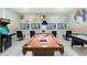 Spacious game room featuring a pool table, arcade game, four TVs, and colorful Pac-Personal themed decor at 1454 Belle Terre Rd, Davenport, FL 33896