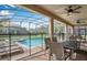 Covered outdoor patio with dining set, overlooking the screened-in pool and backyard at 1454 Belle Terre Rd, Davenport, FL 33896