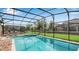 Sparkling screened-in pool and spa with patio furniture, perfect for outdoor relaxation and entertaining at 1454 Belle Terre Rd, Davenport, FL 33896