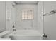 Elegant bathroom with glass block window and tub with marble-look surround at 15832 Autumn Glen Ave, Clermont, FL 34714