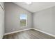 Bright bedroom features a ceiling fan, window with blinds, and wood-look laminate flooring at 15832 Autumn Glen Ave, Clermont, FL 34714
