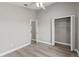 Neutral bedroom with a ceiling fan, closet with shelving, and wood-look laminate flooring at 15832 Autumn Glen Ave, Clermont, FL 34714