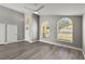Open-concept living room with ceiling fan, large windows, and modern gray paint at 15832 Autumn Glen Ave, Clermont, FL 34714