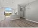 Open-concept living area with gray walls, updated lighting, and kitchen access at 15832 Autumn Glen Ave, Clermont, FL 34714