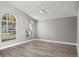 Large living room with arched windows, ceiling fan, and modern gray paint at 15832 Autumn Glen Ave, Clermont, FL 34714