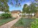 A backyard shed with a brick path, surrounded by greenery and a manicured lawn at 1632 Pinewood Dr, Orlando, FL 32804