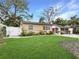 Well-maintained front yard with lush green lawn, mature landscaping, and white picket fence offering a welcoming view at 1632 Pinewood Dr, Orlando, FL 32804