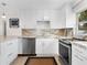 Contemporary kitchen with clean white cabinets, stylish marble countertops, and stainless steel appliances, perfect for cooking and entertaining at 1632 Pinewood Dr, Orlando, FL 32804
