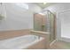 Elegant bathroom featuring a soaking tub, separate glass-enclosed shower, and tile surround for a spa-like experience at 2217 Lelani Cir, Davenport, FL 33897