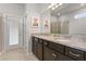 Spacious bathroom with a double vanity, granite countertop, and a glass-enclosed shower for modern convenience at 2217 Lelani Cir, Davenport, FL 33897