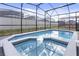 Sparkling pool with screened enclosure, reflecting the sky and surrounding landscape at 2217 Lelani Cir, Davenport, FL 33897