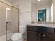 Clean bathroom featuring granite countertops, dark wood cabinetry, a walk-in shower, and modern fixtures at 2221 Lelani Cir, Davenport, FL 33897