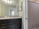 Well-lit bathroom with double sinks, granite countertop, and a shower, offering a functional and stylish space at 2221 Lelani Cir, Davenport, FL 33897