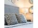 Close-up on patterned throw pillows and mirrored wall decorations in a serene bedroom setting with elegant lighting at 2221 Lelani Cir, Davenport, FL 33897