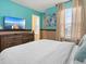 Comfortable bedroom featuring beach themed wall decor and a large dresser with TV at 2221 Lelani Cir, Davenport, FL 33897