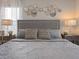 Stylish bedroom features patterned bedding, decorative mirrors, and contemporary bedside lighting for an elegant retreat at 2221 Lelani Cir, Davenport, FL 33897