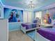Charming bedroom with 'Frozen' themed decor, twin beds, and soft blue walls for a magical atmosphere at 2221 Lelani Cir, Davenport, FL 33897