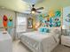 The bedroom is a vibrant tropical paradise with surfer decor, creating a playful and relaxing atmosphere at 2221 Lelani Cir, Davenport, FL 33897
