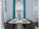 Formal dining room with elegant table setting, modern chandelier, and blue drapes at 2221 Lelani Cir, Davenport, FL 33897