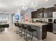 Open-concept kitchen with granite countertops, stainless steel appliances, and breakfast bar at 2221 Lelani Cir, Davenport, FL 33897