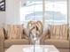 Well-lit sitting area with neutral chairs, patterned pillows, and a stylish decorative object on a glossy table at 2221 Lelani Cir, Davenport, FL 33897
